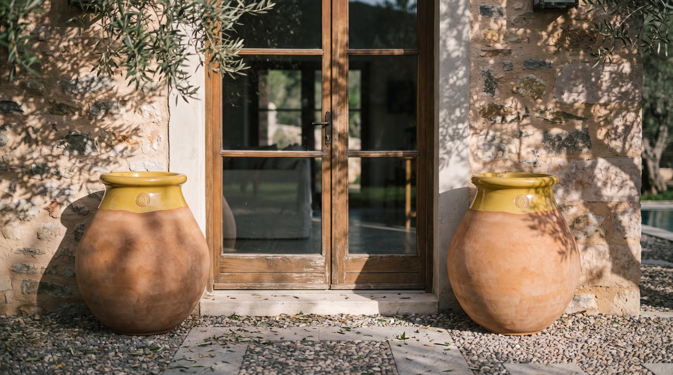 Zwei leere Biots Made in Provence flankieren den Eingang einer mediterranen Villa