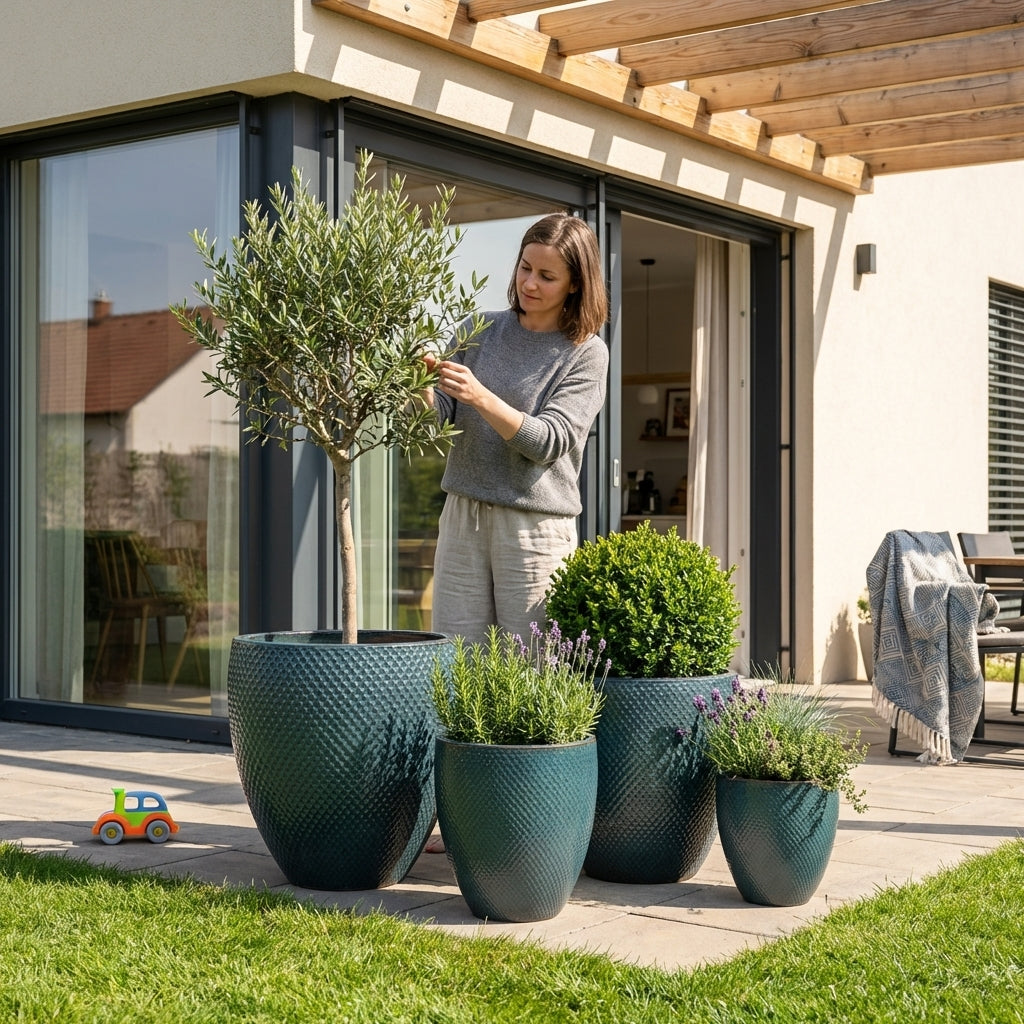 Petrolejově modrý keramický květináč Signac s buxusem v detailním záběru na moderní rodinné terase v jarním slunci.