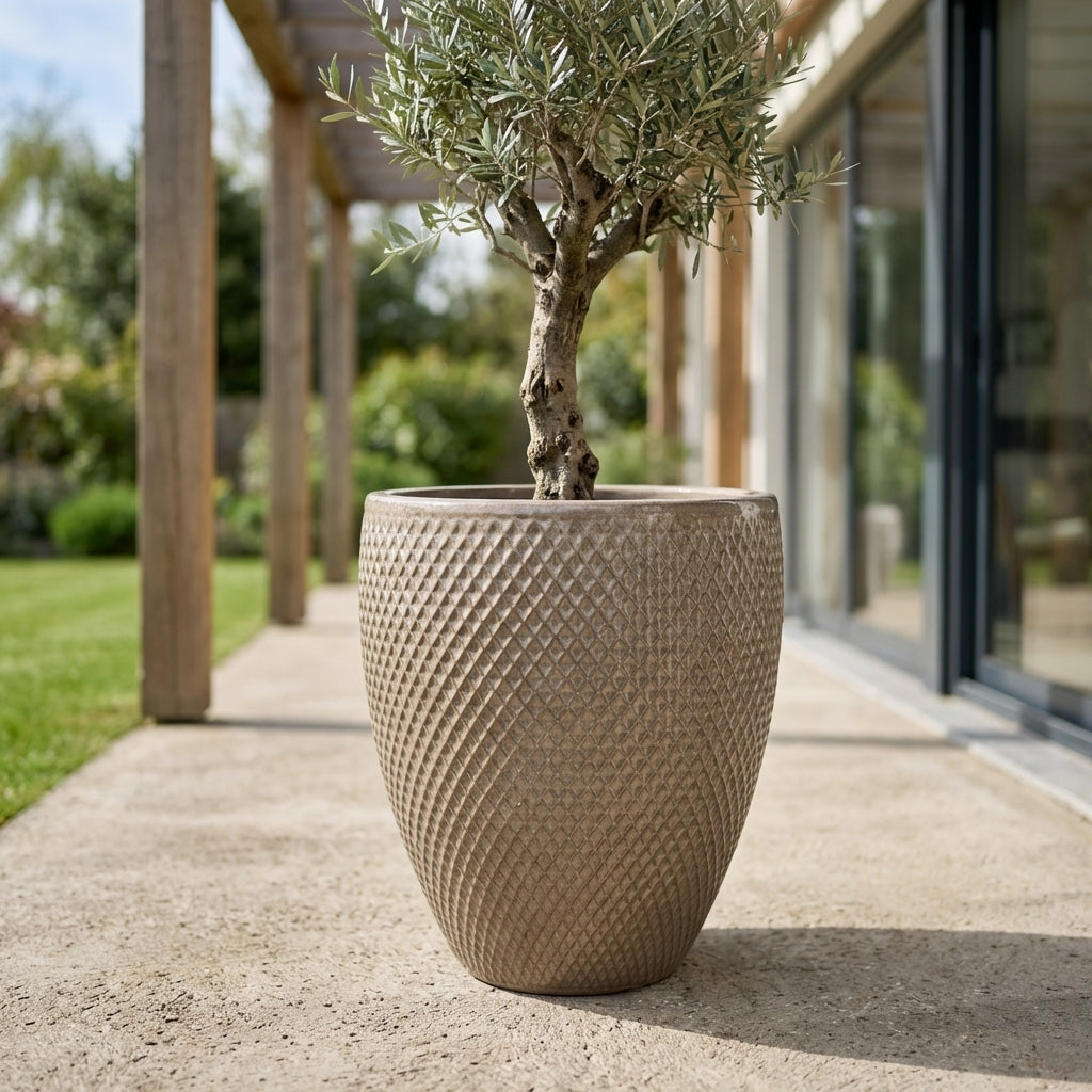 Detailní pohled na Keramický květináč Signac - Písková s rostlinou na prosluněné moderní rodinné terase.