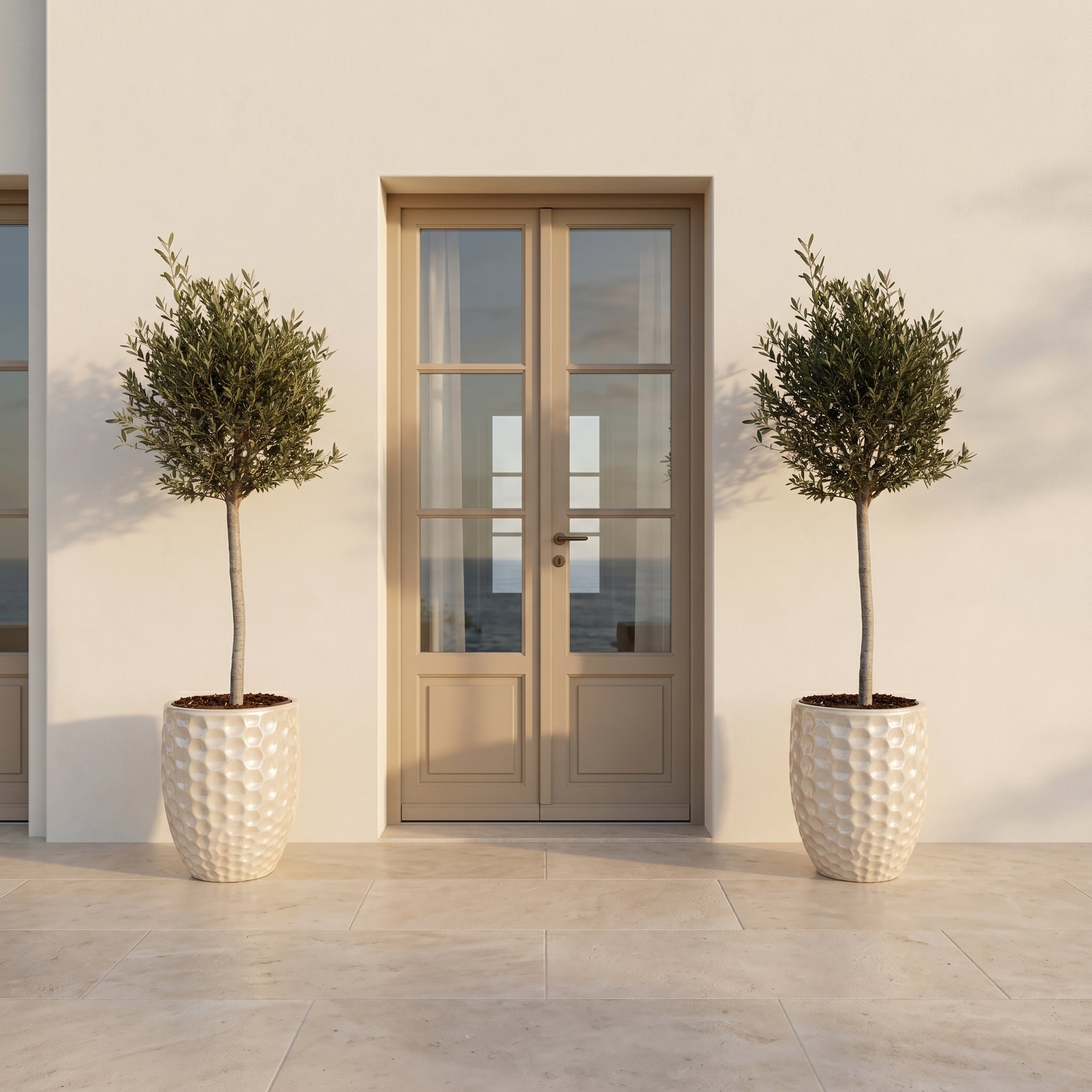 Detail olivovníku v luxusním perlovém květináči MEROVEE 42x55 cm z glazované keramiky na světlé kamenné terase.